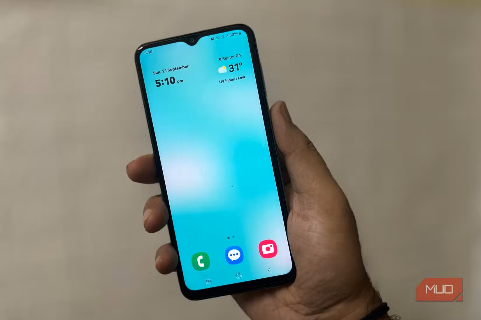 person-holding-samsung-phone-showing-clean-home-screen-with-clock-and-weather.png